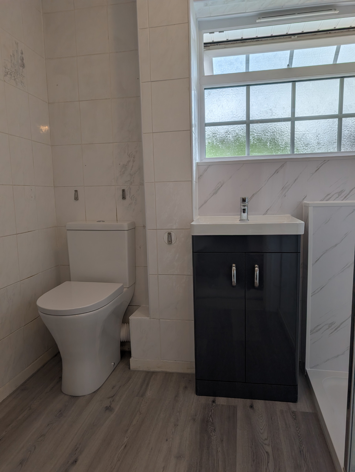 Clean white tiled bathroom with grey vanity — recent project