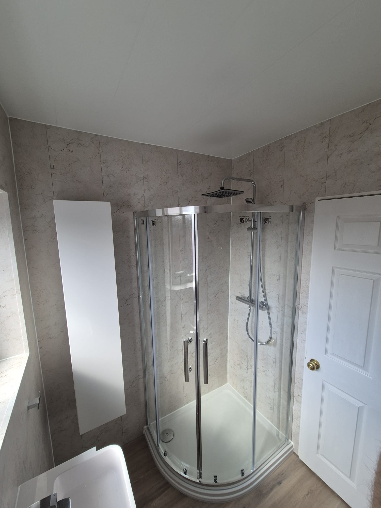 Quadrant shower enclosure with rainfall head and marble-effect panels — recent project
