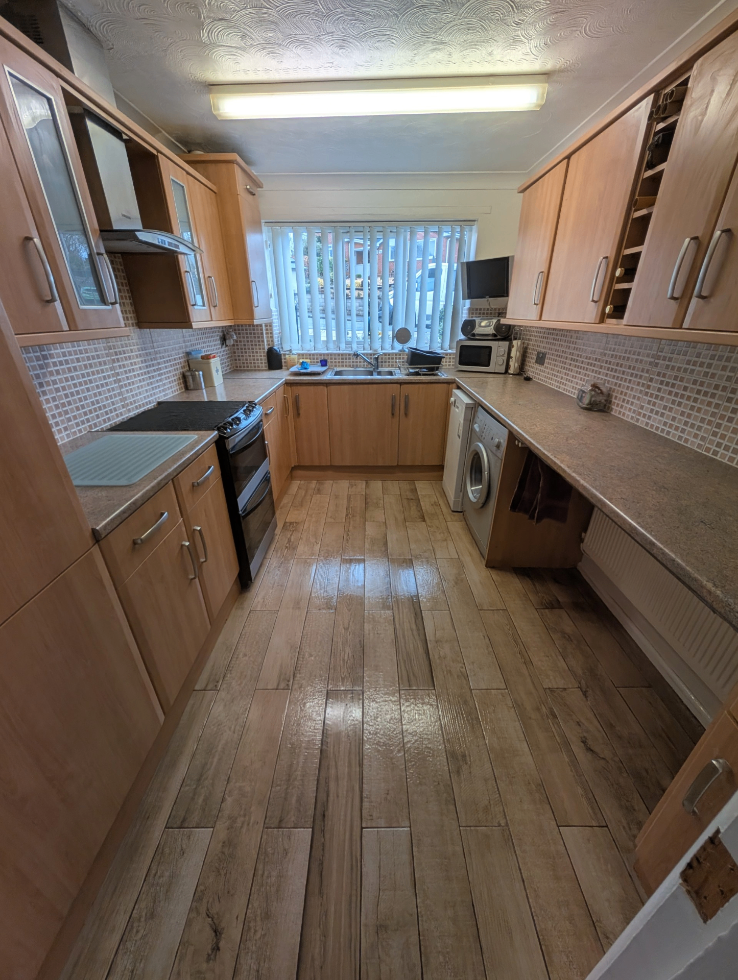 Kitchen flooring fit — wood-effect plank flooring throughout galley kitchen