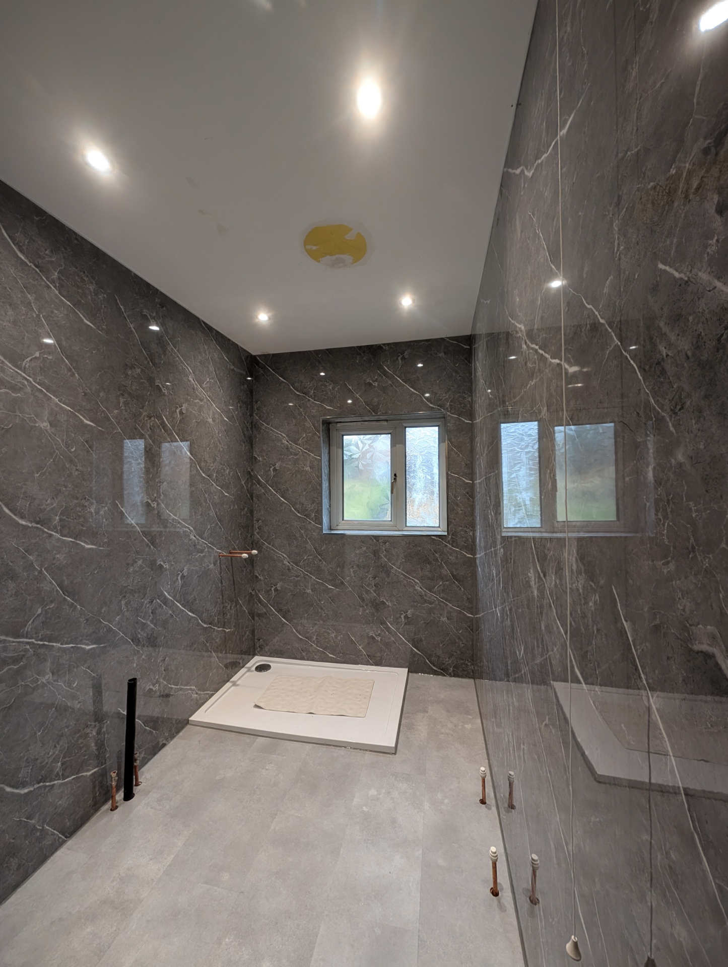 Grey marble-effect wet room with low-profile shower tray and recessed lighting — recent project